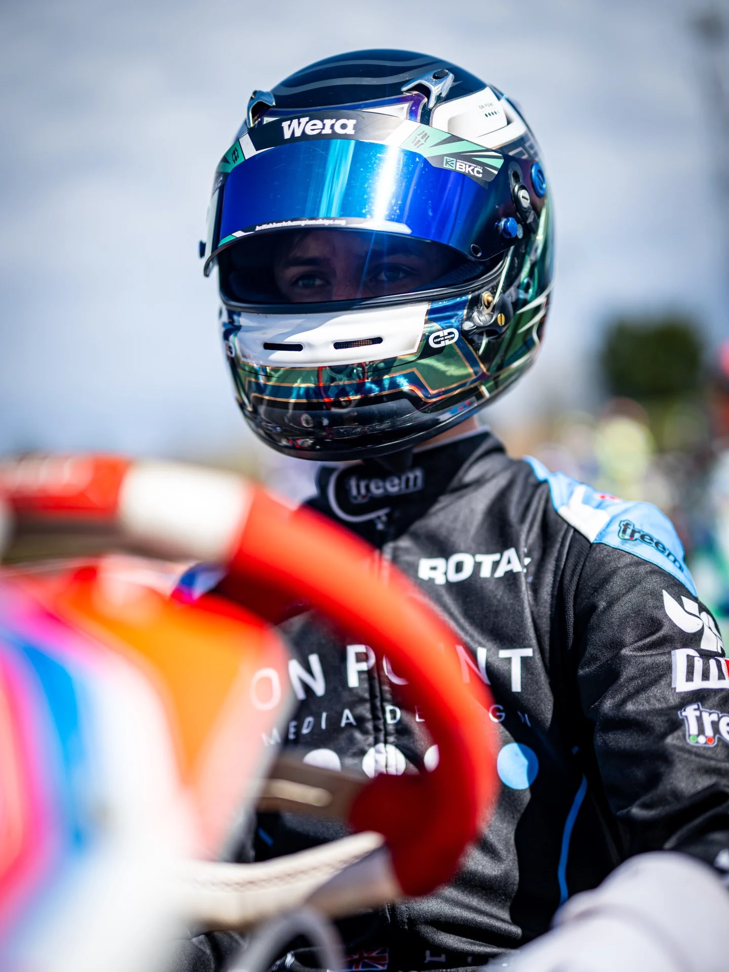 Harrison Crowther in race helmet beside a kart