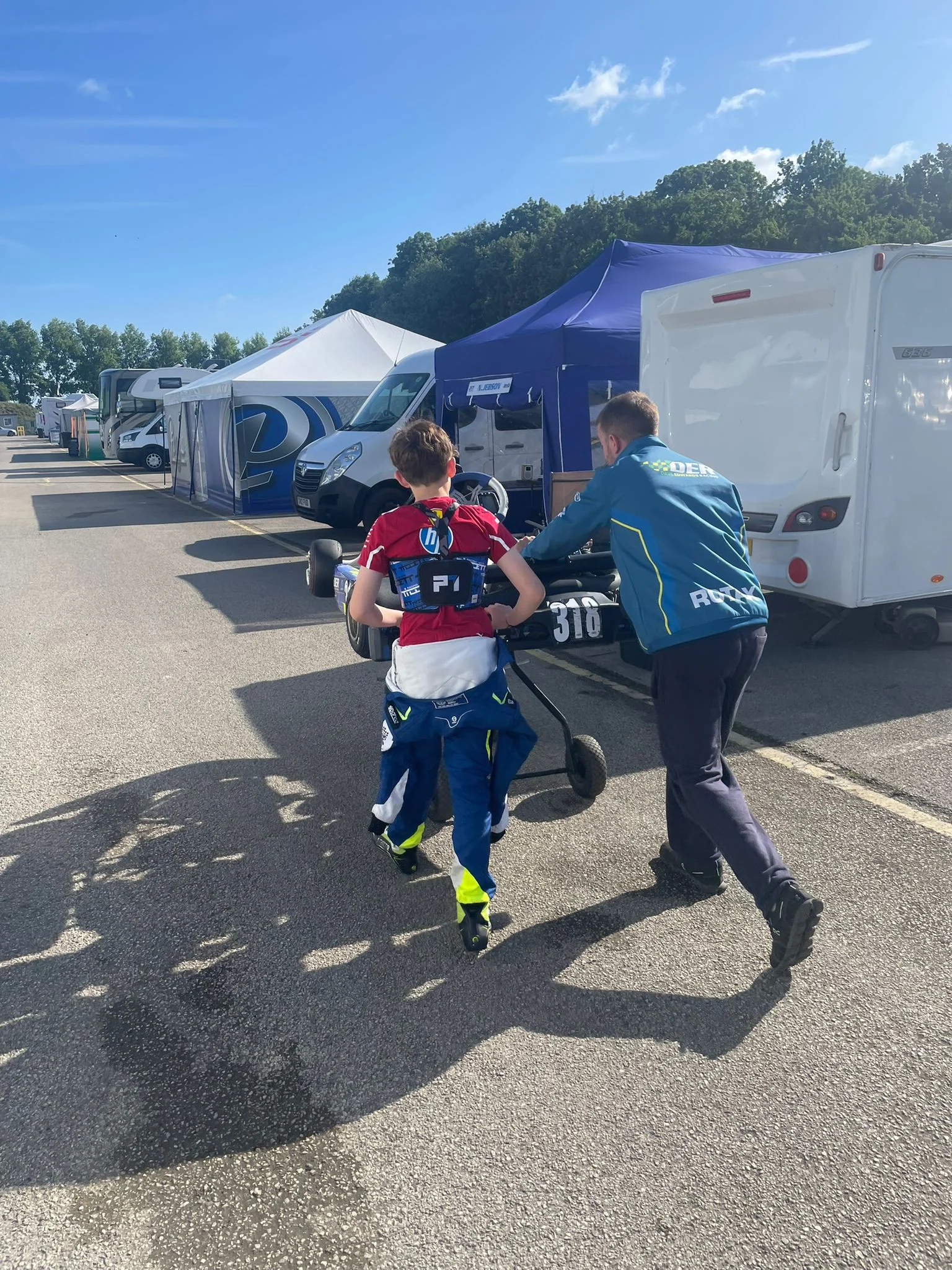 Dave Edwards Racing team pushing a kart through the paddock